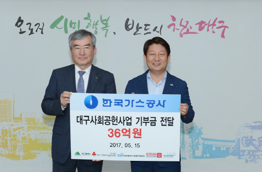 이승훈 한국가스공사 사장(왼쪽)이 권영진 대구시장에게 대구지역 사회공헌사업을 위한 기부금 36억원을 전달한 뒤 기념촬영을 하고 있다. <한국가스공사 제공>